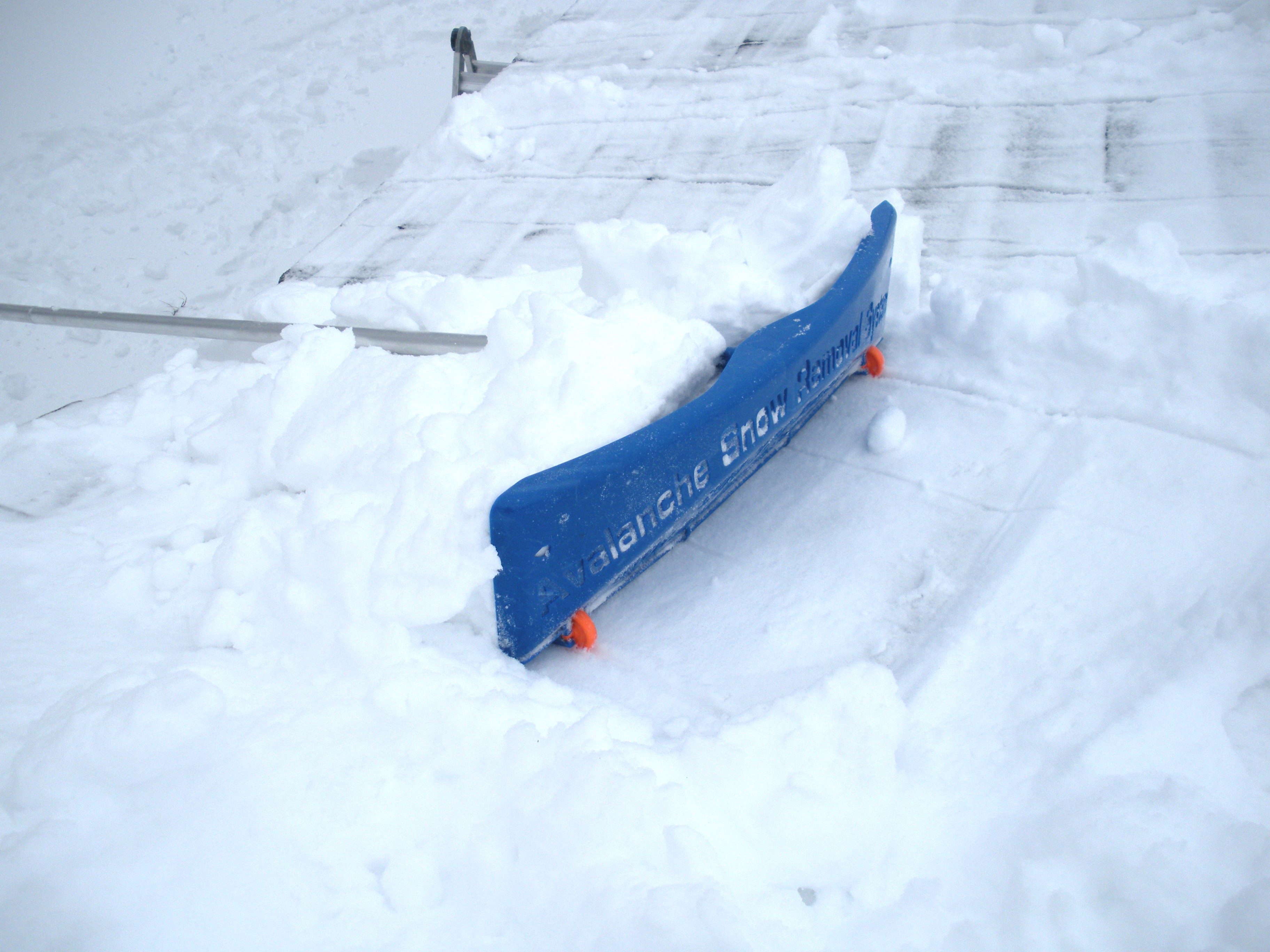 the SnowRake Deluxe 20 clearing snow from a roof